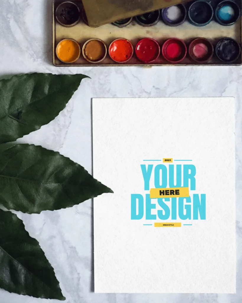flatlay greeting card mockup with leaf and colors on table 