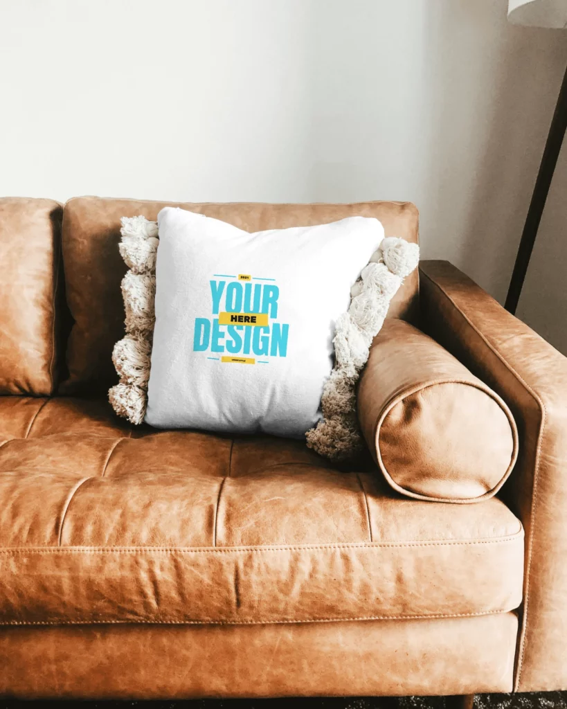 Mockup of a Square Pillow Sitting on a Leather Couch