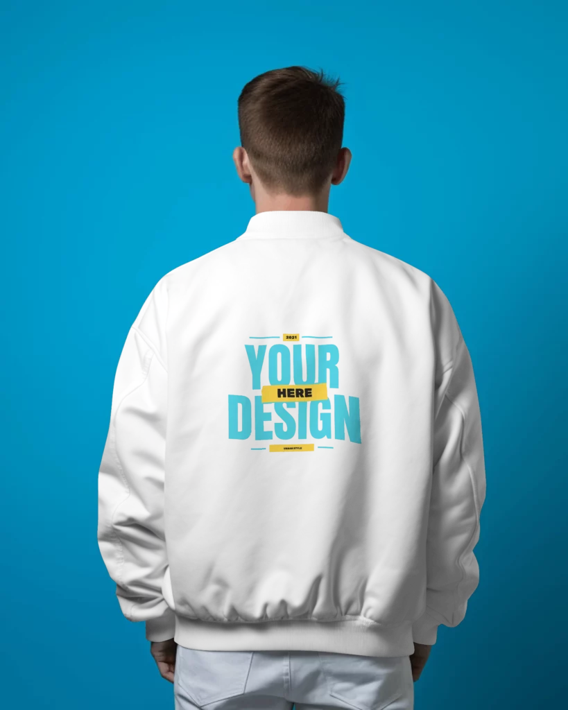 back view of a person wearing varsity jacket standing in front of blue screen