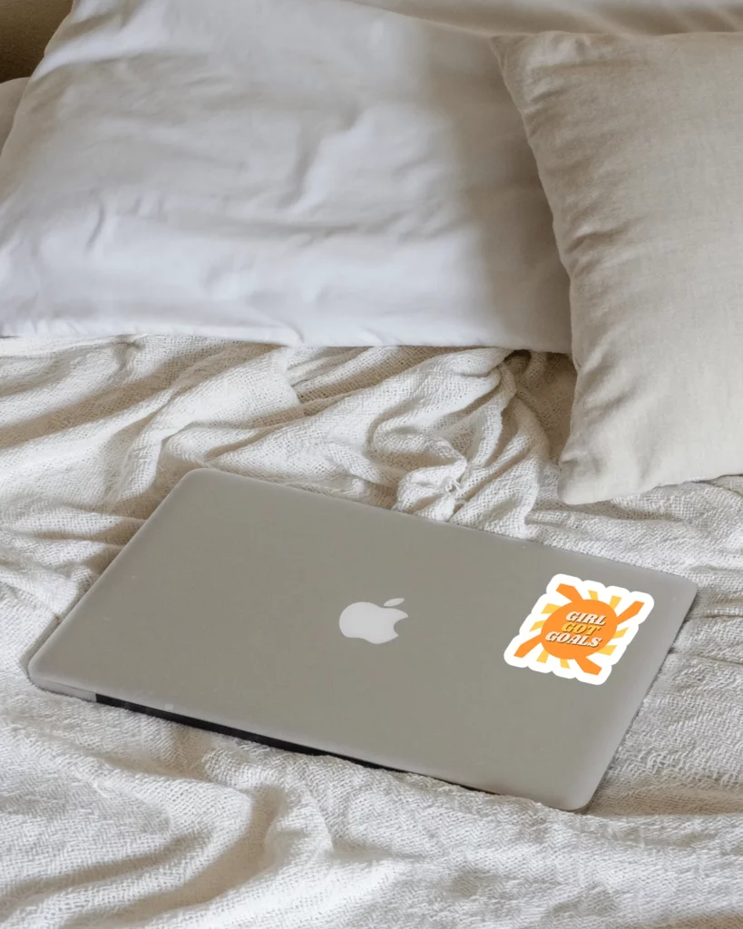 sticker mockup on a macbook lying on a bed