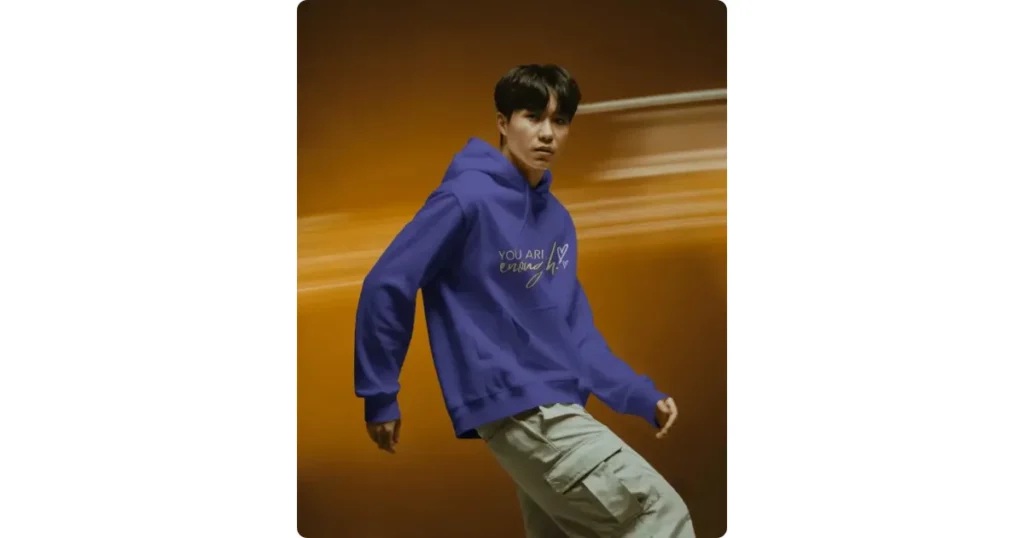 a model in motion wearing a hoodie against an orange blur backdrop