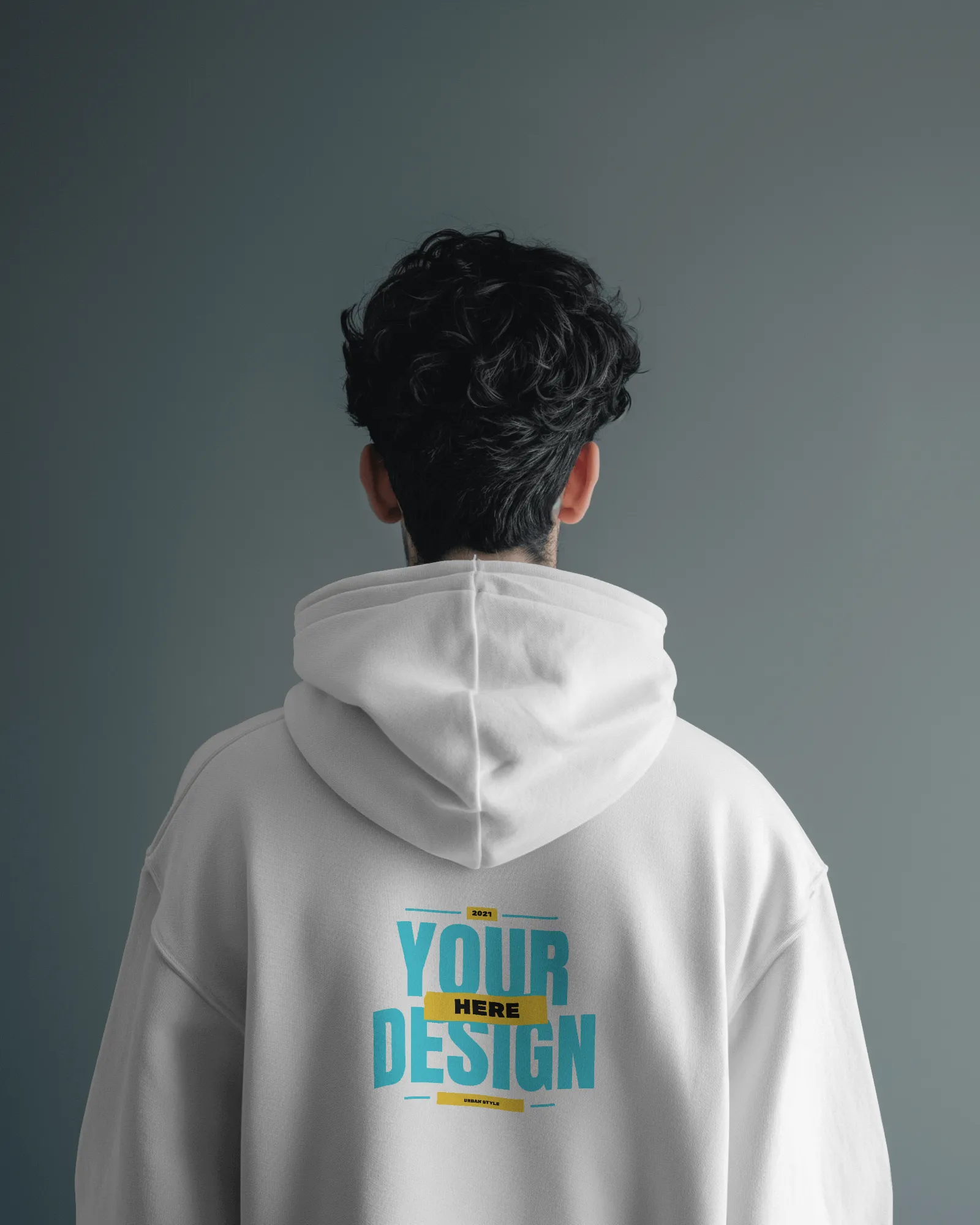 back view of man wearing hoodie mockup in grey studio