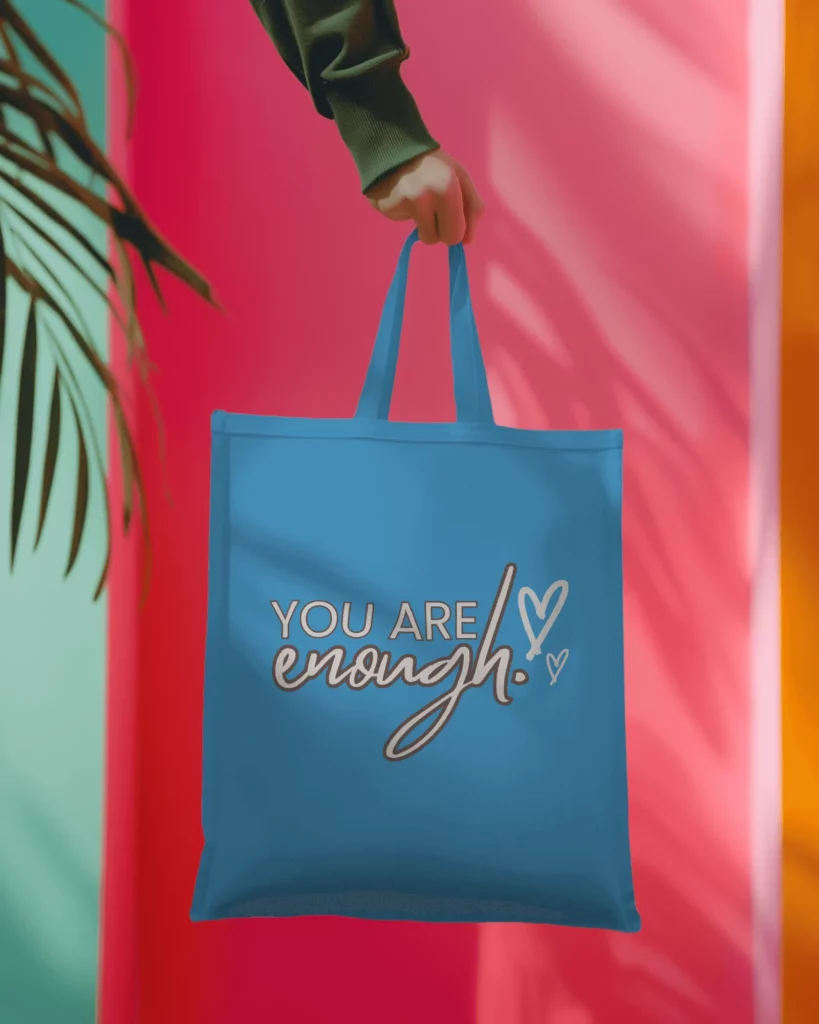 tote bag mockup hanging on hand of a person wearing green sweatshirt
