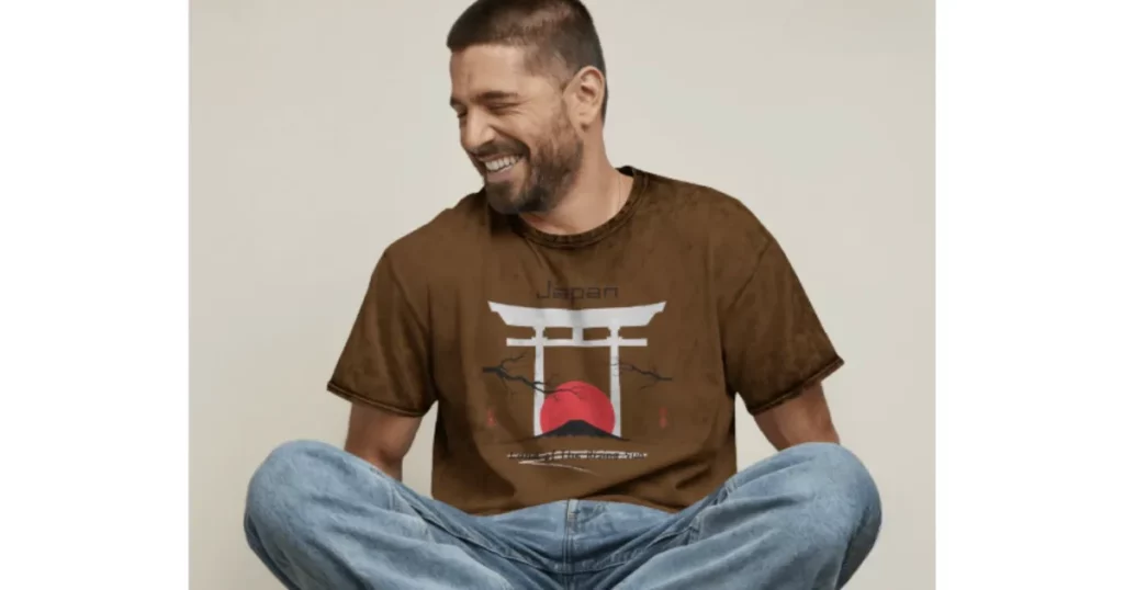 a man sits cross-legged wearing a t-shirt